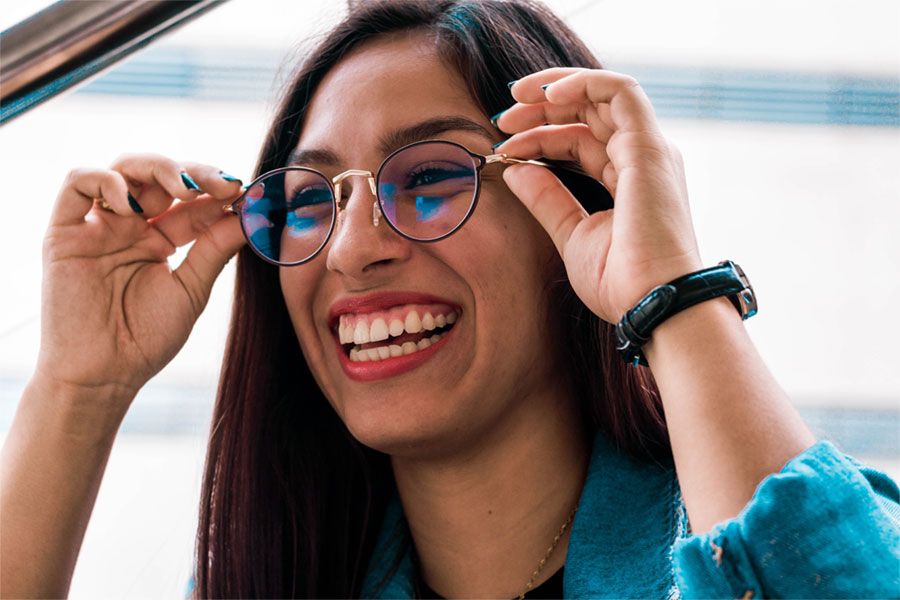 Woman with glasses smiling because she has vision insurance